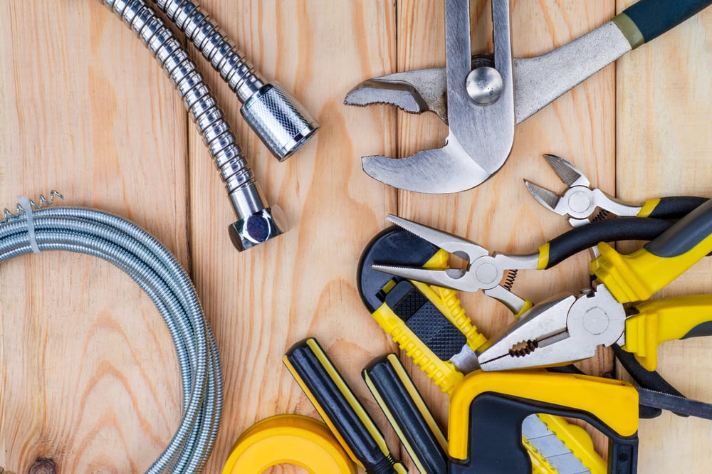 Necessary set of tools for plumbers on wooden background